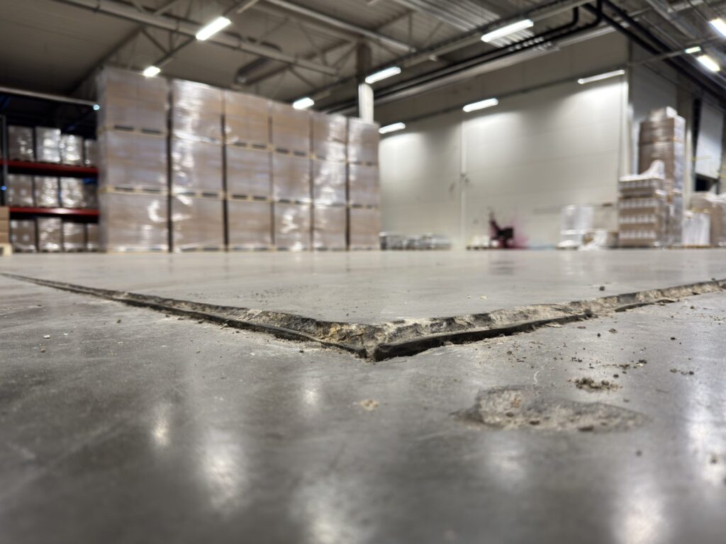 Industrial warehouse floor settlement with slab edge separation caused by subsoil failure