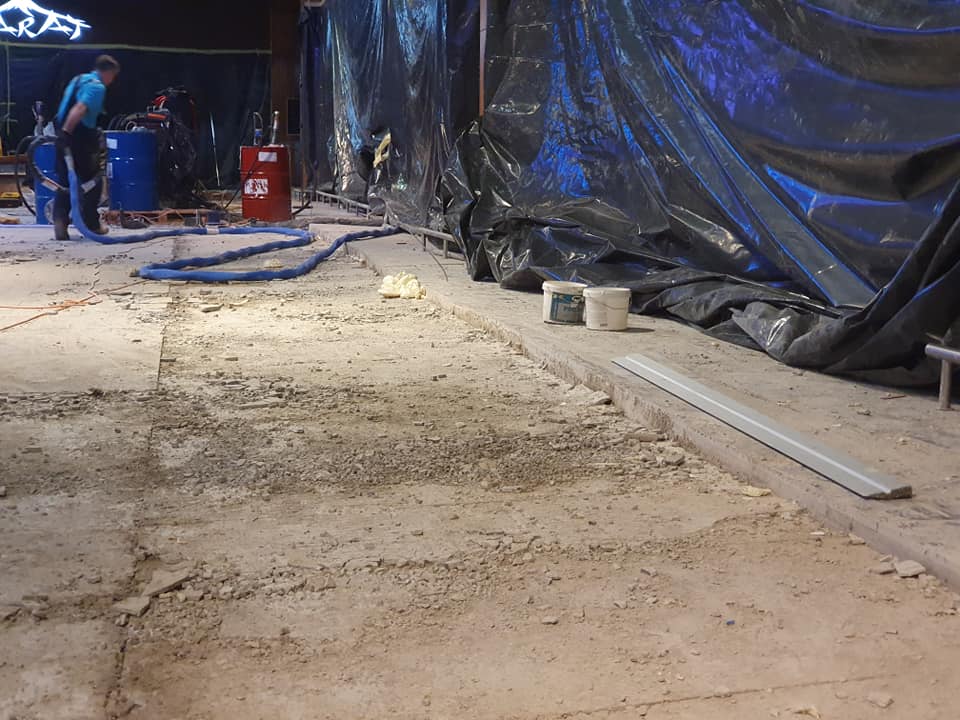 Uneven industrial concrete floor with visible subsidence and damaged base